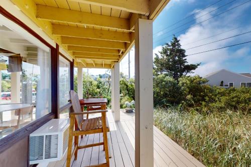a porch of a house with a chair on it at Mermaid Cove in North Truro