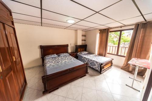 ein Schlafzimmer mit zwei Betten und einem Fenster in der Unterkunft Lindo apto al lado del parque del ingenio in Cali