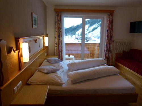 a room with three pillows on a bed with a window at Montanara Apartment & Zimmer in Ramsau am Dachstein