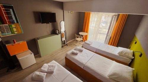 a small room with two beds and a window at Boutique Hotel B Plus in Peje