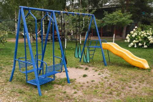 a playground with two swings and a slide at Senelio Romo Sodyba in Molėtai