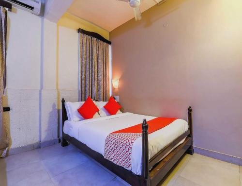 a bedroom with a bed with red pillows at Hotel O Kams Coco De Parra in Goa