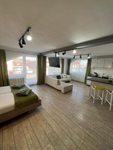 a bedroom with a bed and a couch and a kitchen at Bruno Apartments in Cluj-Napoca