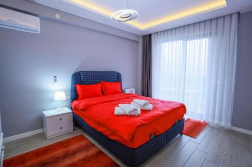 a bedroom with a red bed with two towels on it at Zümrüt Villaları in Sapanca