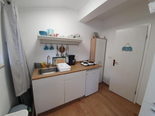 een kleine keuken met een spoelbak en een koelkast bij Una in Umag