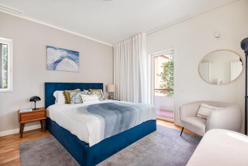 a bedroom with a bed and a chair and a window at Bombarda Homes in Porto