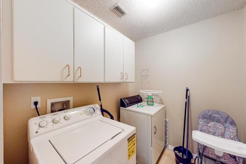 eine Küche mit einer Waschmaschine und einem Kühlschrank in der Unterkunft SunKissed Retreat in Orlando
