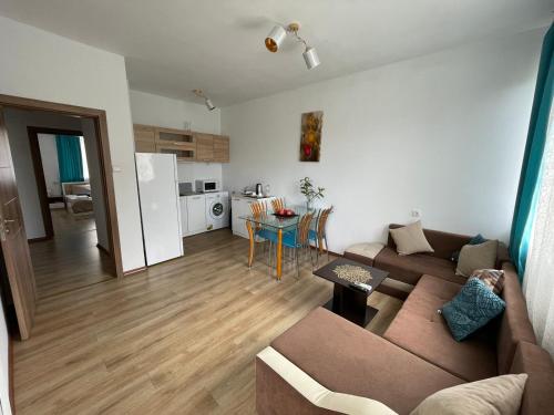ein Wohnzimmer mit einem braunen Sofa und einer Küche in der Unterkunft THE CENTER Apartments Comfort in Sandanski