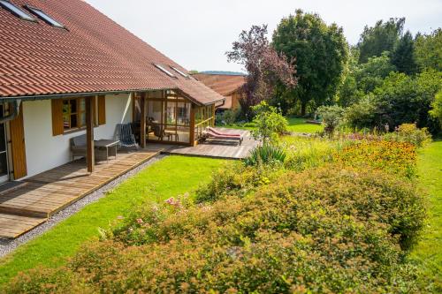 a garden with a wooden deck and a house at Ferienwohnung Bayerwaldblick Hexental in Bogen