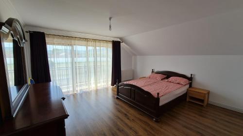 a bedroom with a bed and a large window at Casa Elisabeta in Bilca