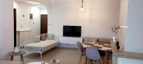 ein Wohnzimmer mit einem Sofa und einem Tisch mit Stühlen in der Unterkunft Arya Guesthouse in Poligiros