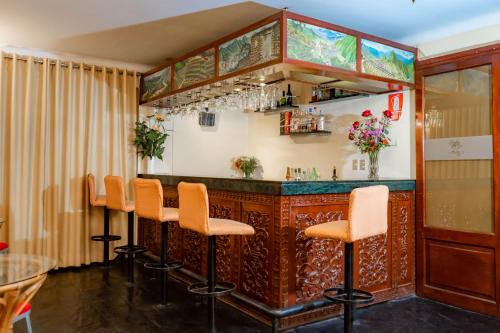 un bar en un restaurante con taburetes naranjas en Hotel Agustos Cusco, en Cusco