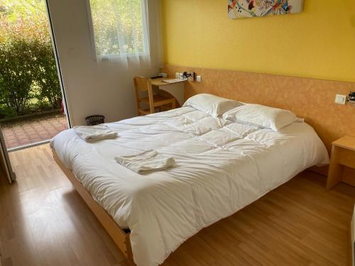 a large bed with white sheets and towels on it at Lutea in Riom-ès-Montagnes