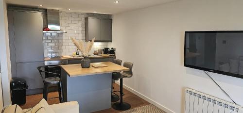 a kitchen with a desk and a tv on a wall at Rutland Point apartment Serviced Accommodation Keystones Property Services in Morcott