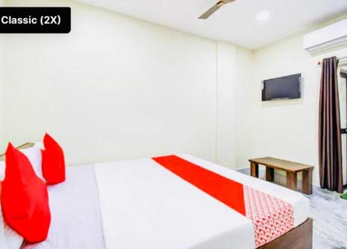 Schlafzimmer mit einem roten und weißen Bett und einem Tisch in der Unterkunft Hotel Somnath Guest House ! Puri in Puri