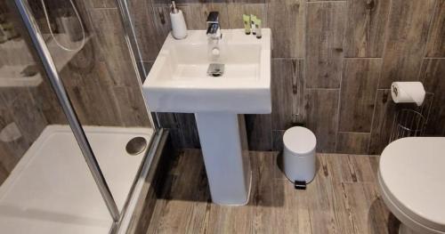 a bathroom with a white sink and a toilet at Rutland Point apartment Serviced Accommodation Keystones Property Services in Morcott