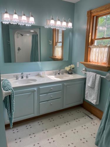 a bathroom with two sinks and a mirror at The Inn at Woodsong Acres in Conneaut