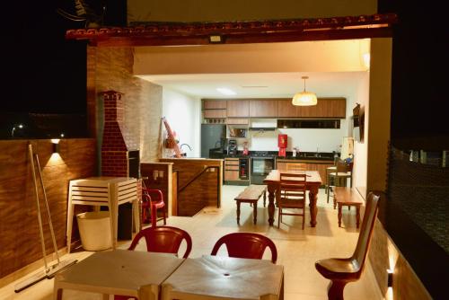 una cucina e una sala da pranzo con tavoli e sedie di Casa De Graziele & Nicolas a Itaberaba