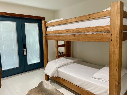 a bedroom with two bunk beds and two windows at Blanco County Inn & Guesthouses in Blanco