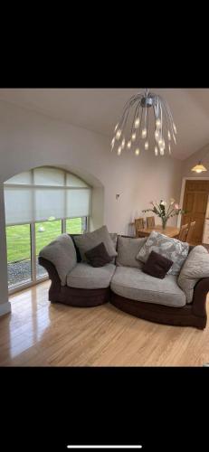 sala de estar con sofá y lámpara de araña en Glenwood house, en Walterstown