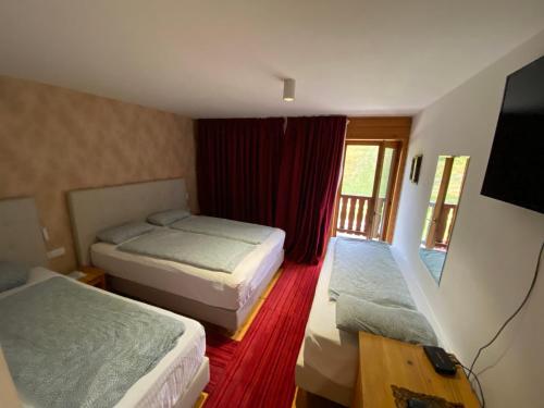 a hotel room with two beds and a flat screen tv at Pansion Vlašić Ski in Šišava