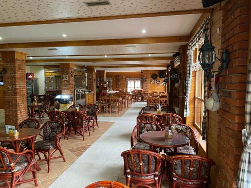 a restaurant with tables and chairs and a brick wall at Pansion Vlašić Ski in Šišava