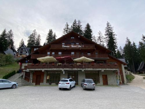 a building with two cars parked in front of it at Pansion Vlašić Ski in Šišava
