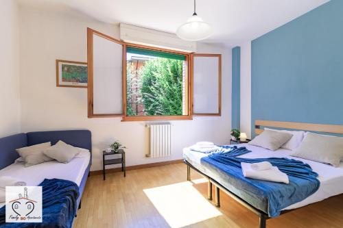 a bedroom with two beds and a window at FamilyBO Apartments Sant'Orsola in Bologna
