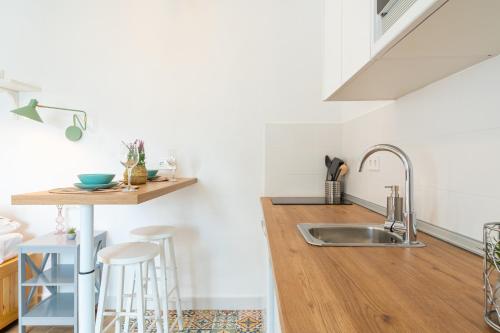 a kitchen with a sink and a counter with stools at Casa La Fontana 2 in Vejer de la Frontera