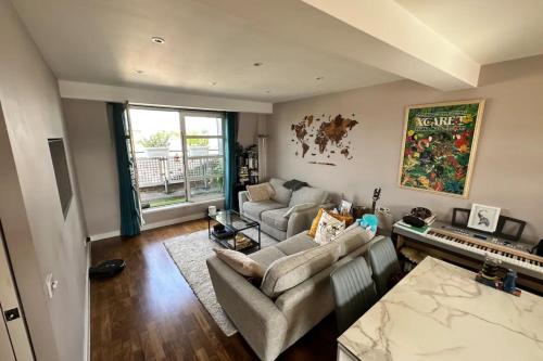 a living room with two couches and a piano at Charming 2BD Flat w Chic Terrace Kentish Town in London