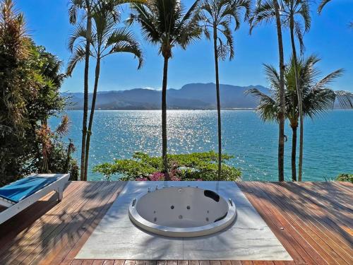 una bañera sentada en una mesa junto al agua en Barra do Piuva Porto Hotel, en Ilhabela