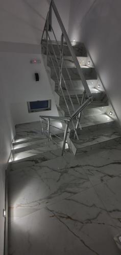 a staircase in an empty room with a marble floor at ITACA apartman Krupanj in Krupanj