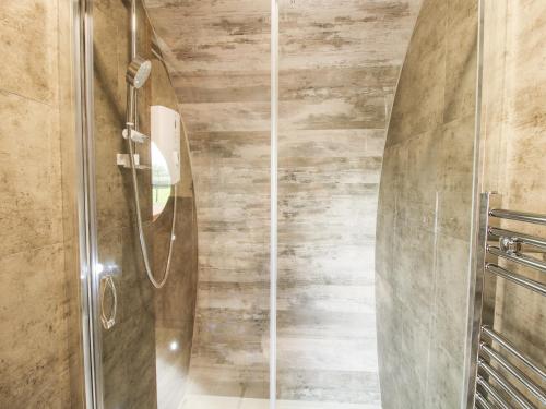 a shower with a glass door in a bathroom at Shire's End in Caynham
