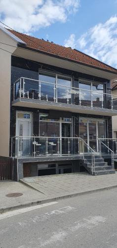 ein Gebäude mit Balkon und vielen Fenstern in der Unterkunft ITACA apartman Krupanj in Krupanj