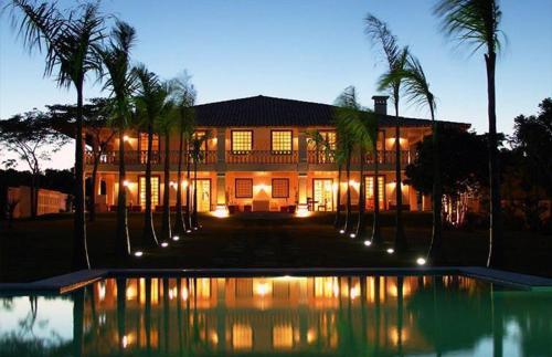 a large house with a swimming pool in front of it at Casa Grande São Vicente in Arraial d'Ajuda