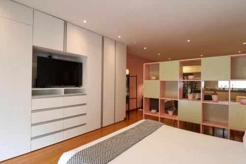 a bedroom with white cabinets and a tv and a bed at Las Mimosas by Wynwood House in Lima
