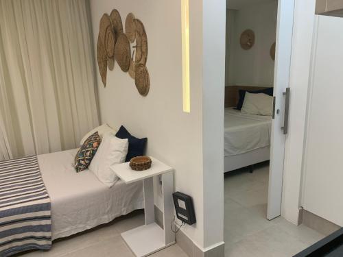 ein kleines Schlafzimmer mit einem Bett und einem Spiegel in der Unterkunft Lindo e bem localizado in Porto De Galinhas