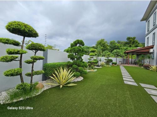 a garden with trees and grass and a building at Luxurious Home Villa , Ipoh with Karaoke, Snooker for 15-20 pax in Ipoh