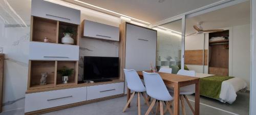 a room with a table and chairs and a bedroom at Principado Benidorm Suites Levante in Benidorm