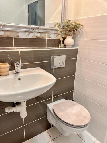 a bathroom with a sink and a toilet and a mirror at Little View in Liptovský Mikuláš
