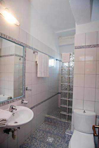a bathroom with a toilet and a sink and a shower at Nepheli in Paralia Katerinis