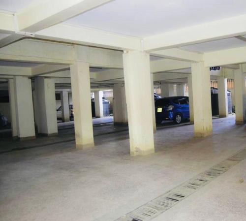 an empty parking garage with a blue car parked in it at Homes by Essyruby in Nairobi