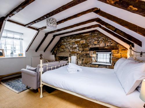 a bedroom with a large bed and a stone wall at Pass the Keys Lovely Old Fishermans Cottage in Anstruther