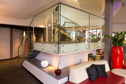 a living room with a glass case on the wall at Mercure Strasbourg Aéroport in Ostwald