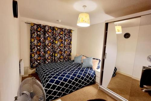 a bedroom with a bed with a curtain and a window at Entire Home in East London E3 near Bromley By Bow Station in London