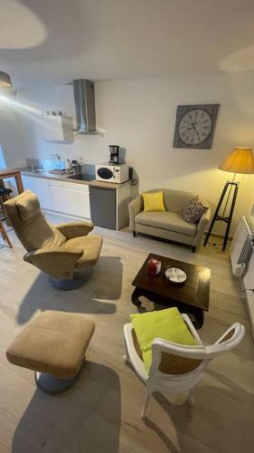 un salon avec des chaises, un canapé et une table dans l'établissement Maison Moderne et Confortable centre Bretagne, à Plouguenast Langast