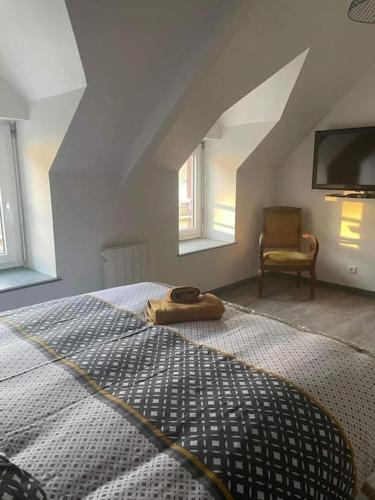une chambre avec un grand lit et une chaise dans l'établissement Maison Moderne et Confortable centre Bretagne, à Plouguenast Langast