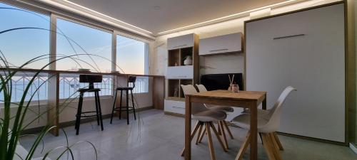 a kitchen with a table and chairs in a room at Principado Benidorm Suites Levante in Benidorm