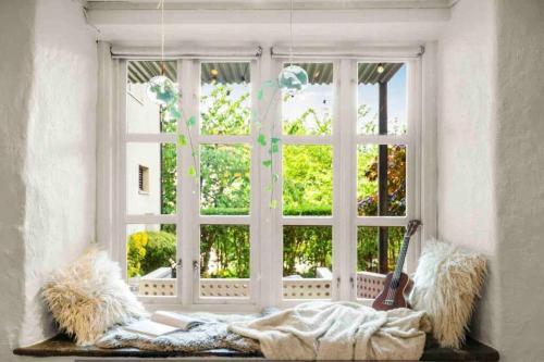 Una mujer acostada sobre una manta frente a una ventana. en The old bakery in Sandviken, en Bergen