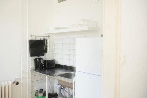 una pequeña cocina con fregadero y nevera. en Stadtoase Wohnung nahe Hauptbahnhof, en Coblenza